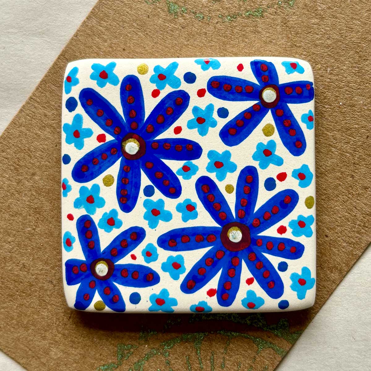 square ceramic brooch with hand painted blue floral pattern