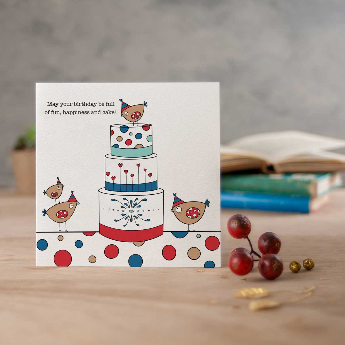 square card with birdies in party hats stood on, and around a cake, and the words may your birthday be full of fun, happiness and cake!