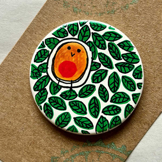circular ceramic brooch with hand painted leaves and robin blob bird illustration