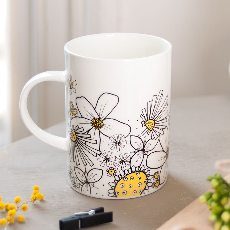 White mug with black and yellow floral design 