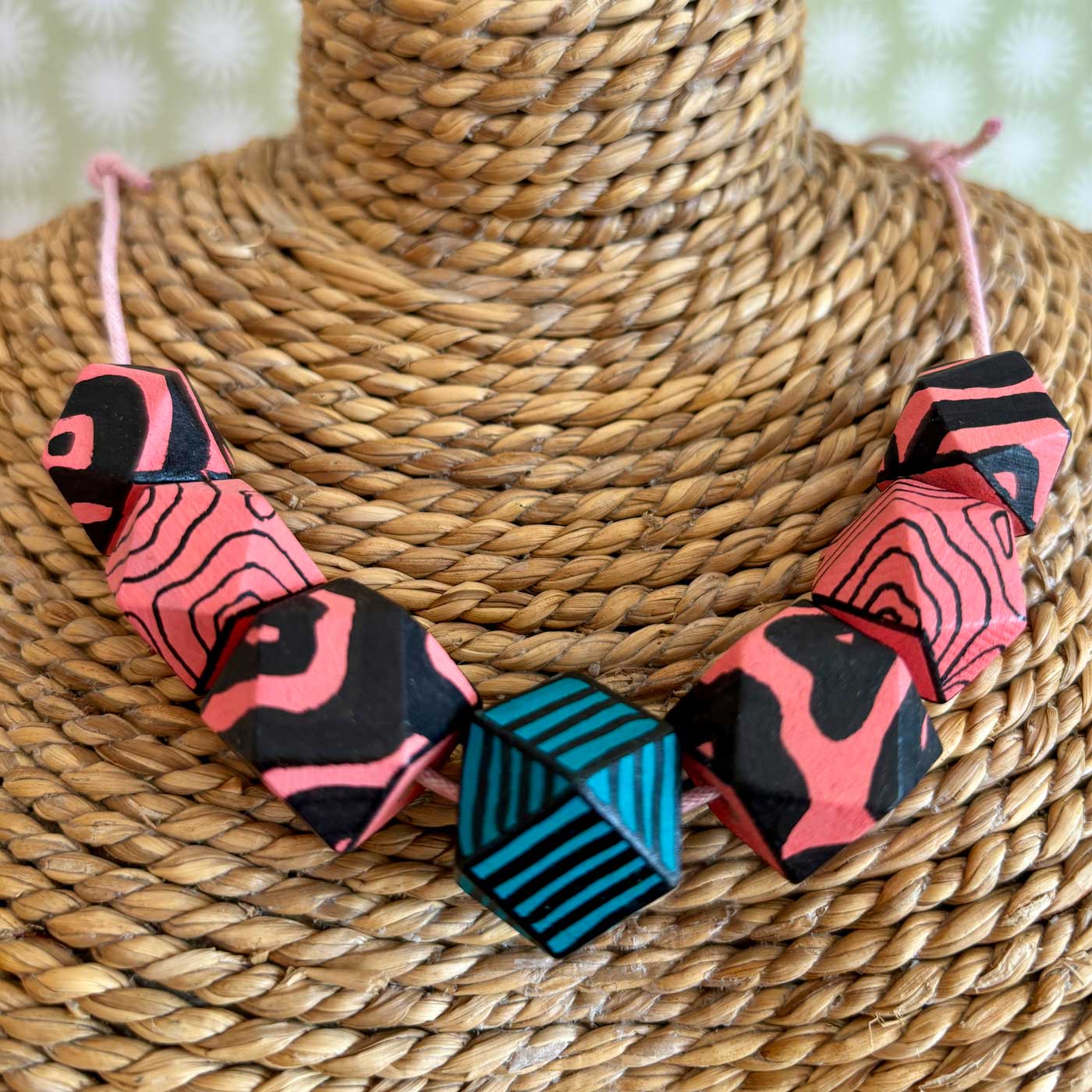 faceted wooden beads painted pink and then illustrated with a black animal print pattern