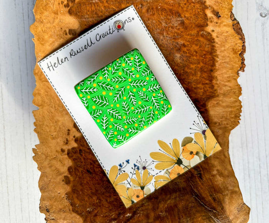 square ceramic brooch hand painted with a bright green leaf pattern