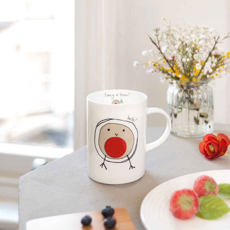 Mug with a bird design on a table with flowers and food
