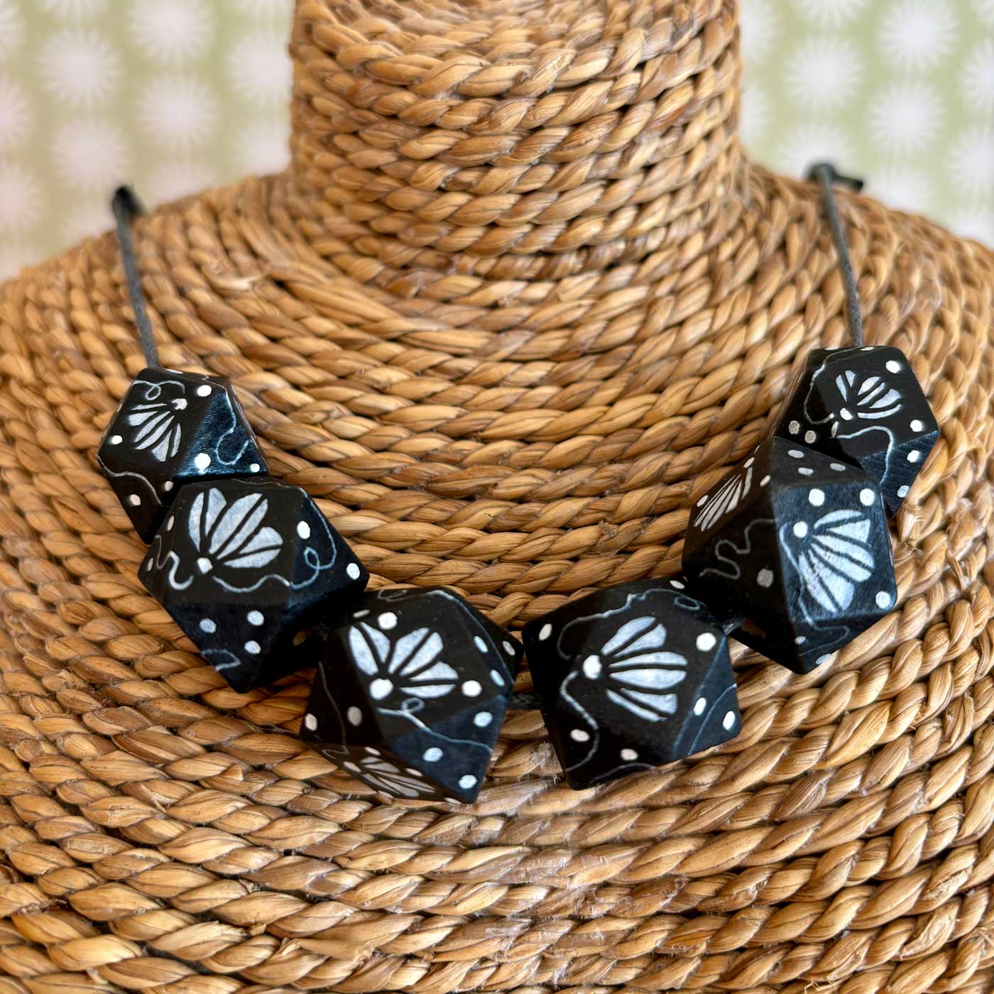 black wooden bead necklace with hand painted white illustrated flowers