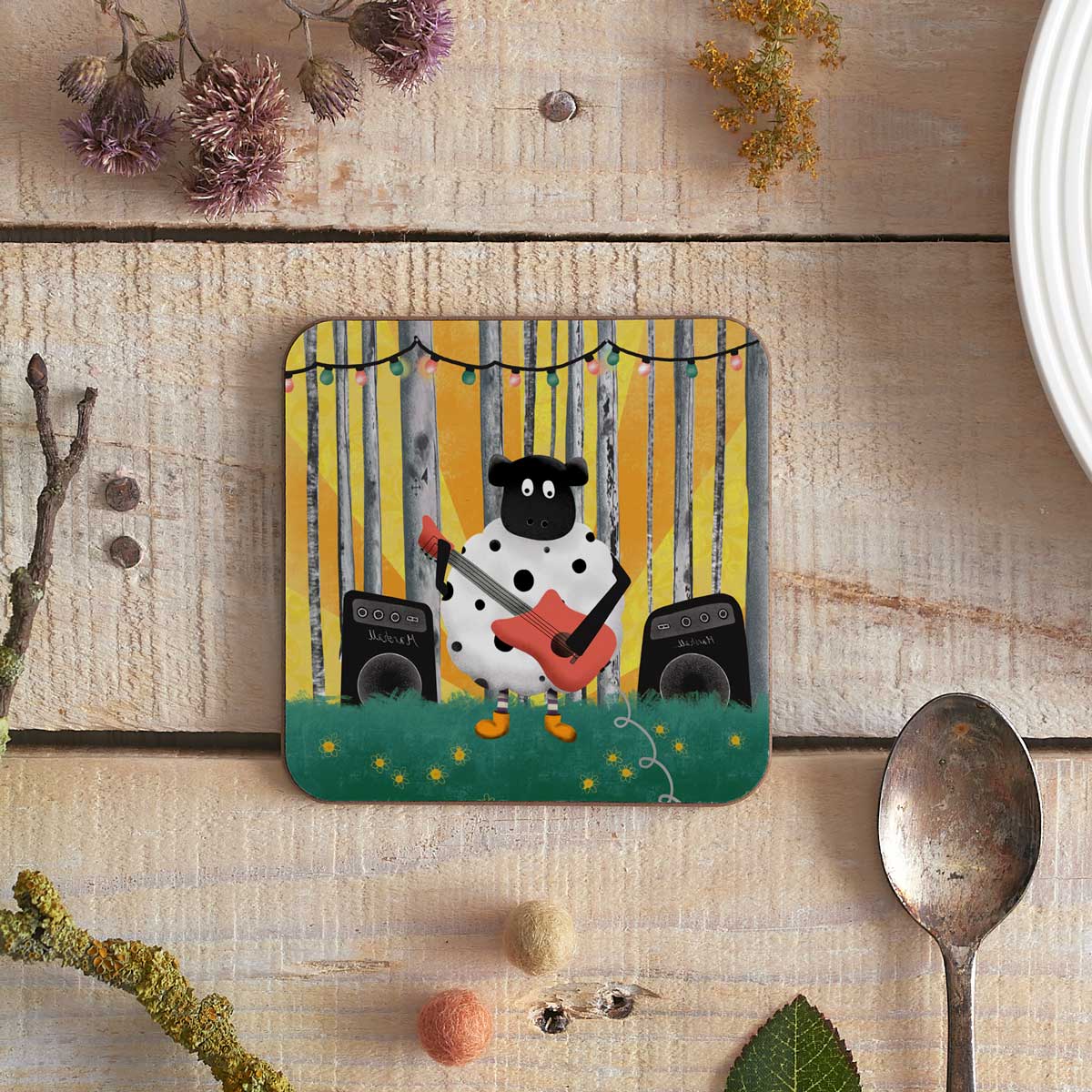 square coaster with illustration of a sheep playing an electric guitar