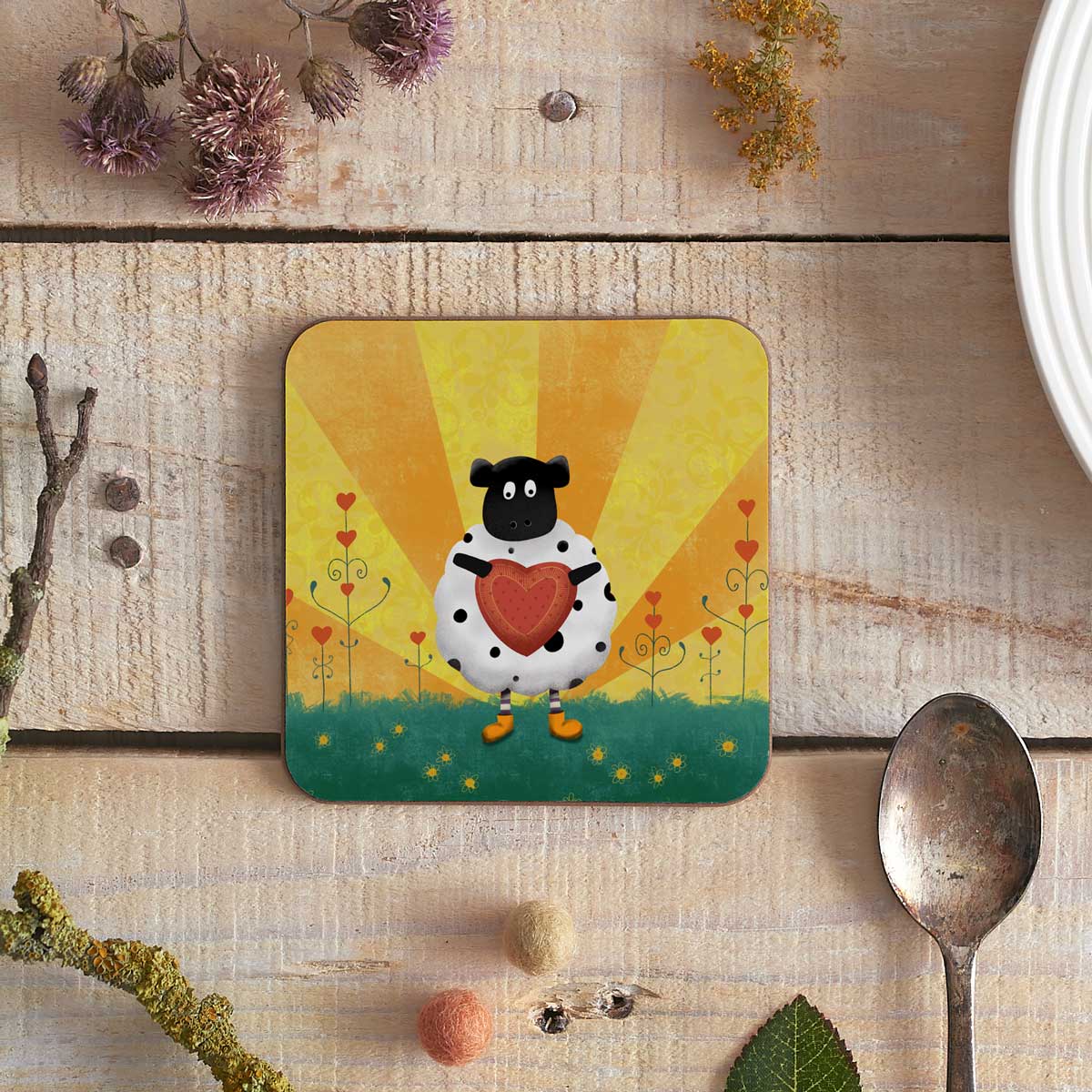 square coaster with image of a sheep holding a heart