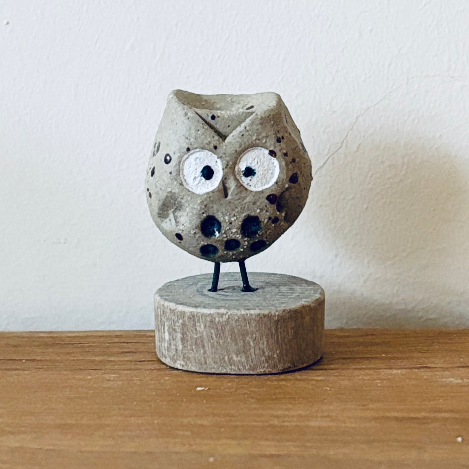 Tiny ceramic owl stood on a little slice of wood