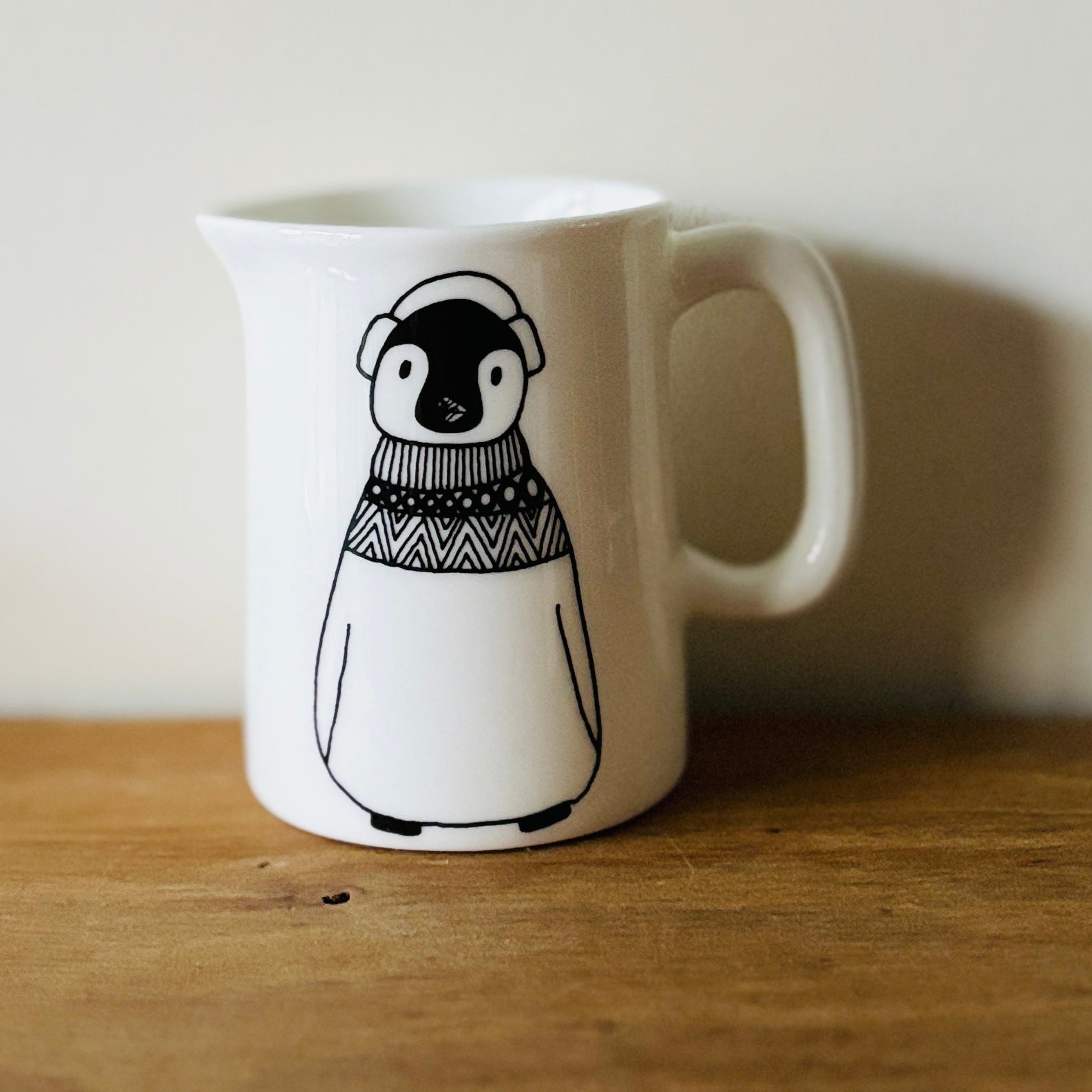 fine china mini jug with penguin wearing winter clothes illustration