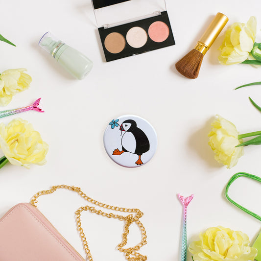 Circular pocket mirror with puffin and flower illustration 