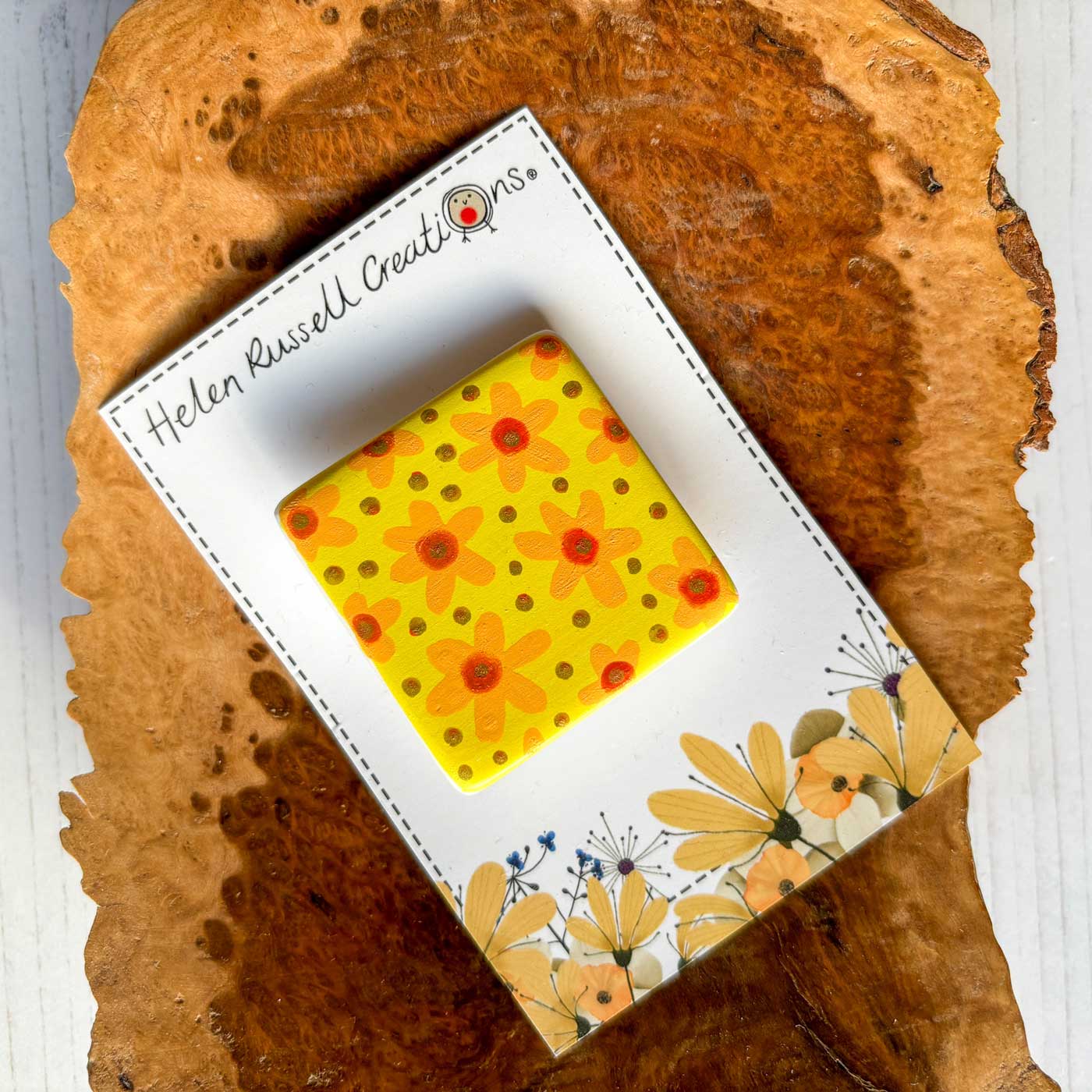 square ceramic brooch hand painted with a cheery yellow and orange floral design