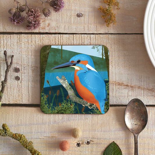 square coaster with an illustration of a kingfisher on a riverbank
