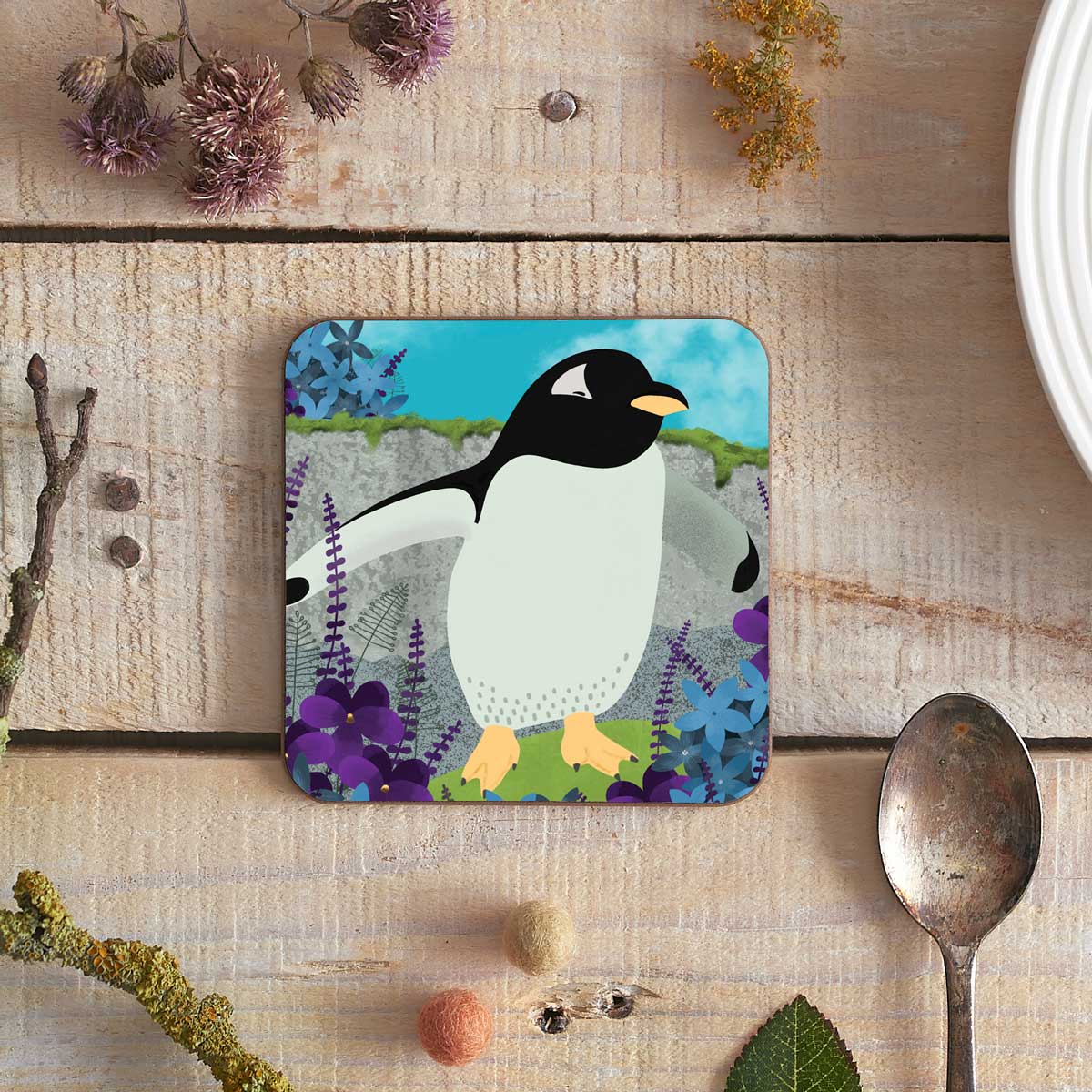 square coaster with a penguin and flowers illustration