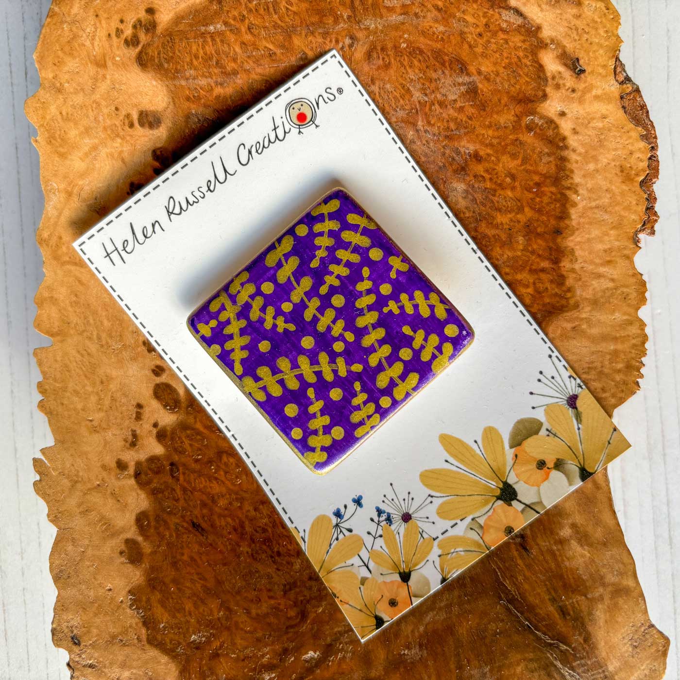 square ceramic brooch hand decorated with purple and gold pattern