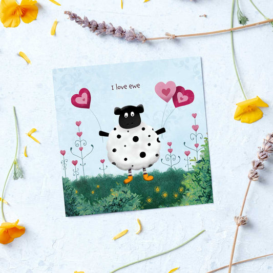 greeting card with a sheep holding heart shaped balloons