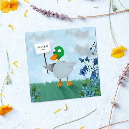 greeting card with a duck holding a sign saying thinking of you