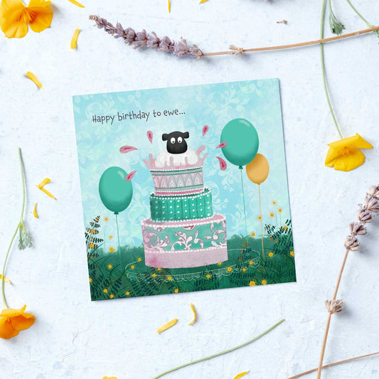 greeting card with an illustration of a sheep popping out of a birthday cake