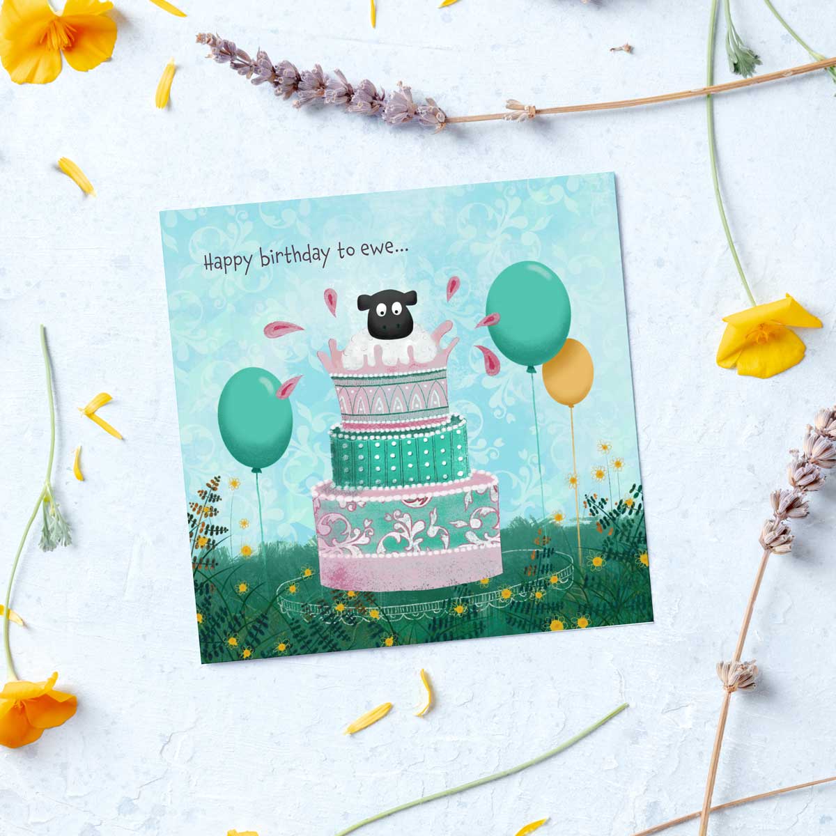 greeting card with an illustration of a sheep popping out of a birthday cake